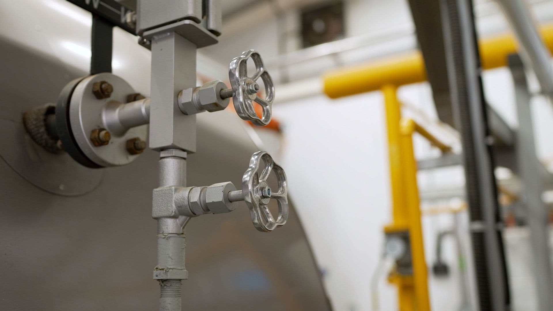Commercial boiler room with multiple high-efficiency boilers, industrial piping, and mechanical equipment providing centralized hot water and heating for a large building.