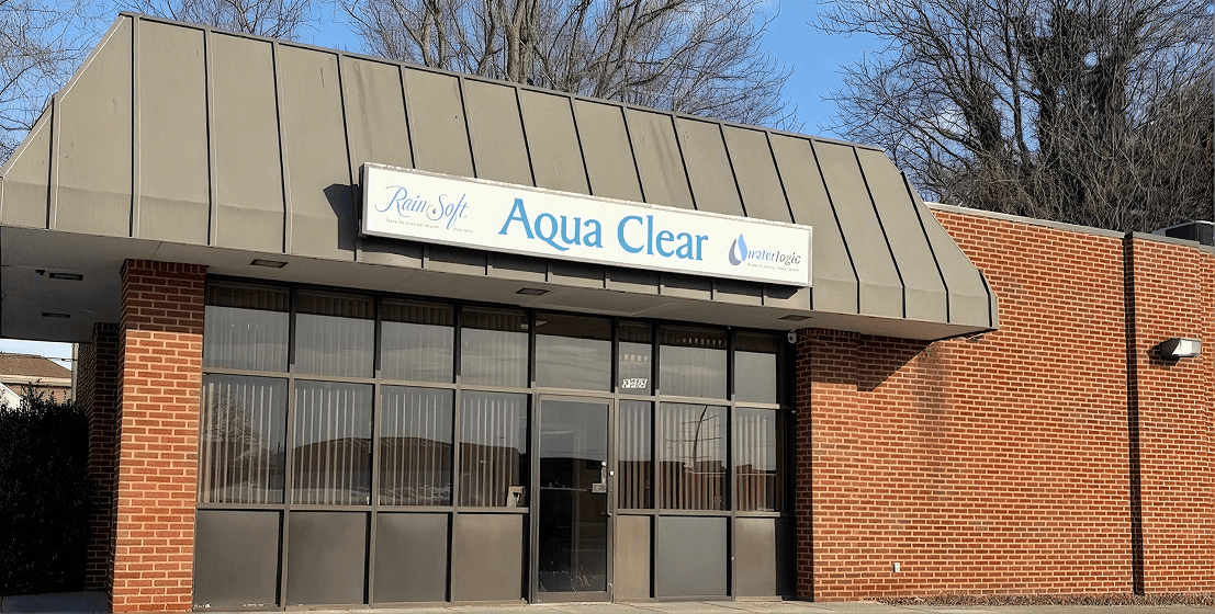Front exterior of Aqua Clear's brick office building with branded RainSoft, Aqua Clear, and Waterlogic signage above the main entrance on a clear day.