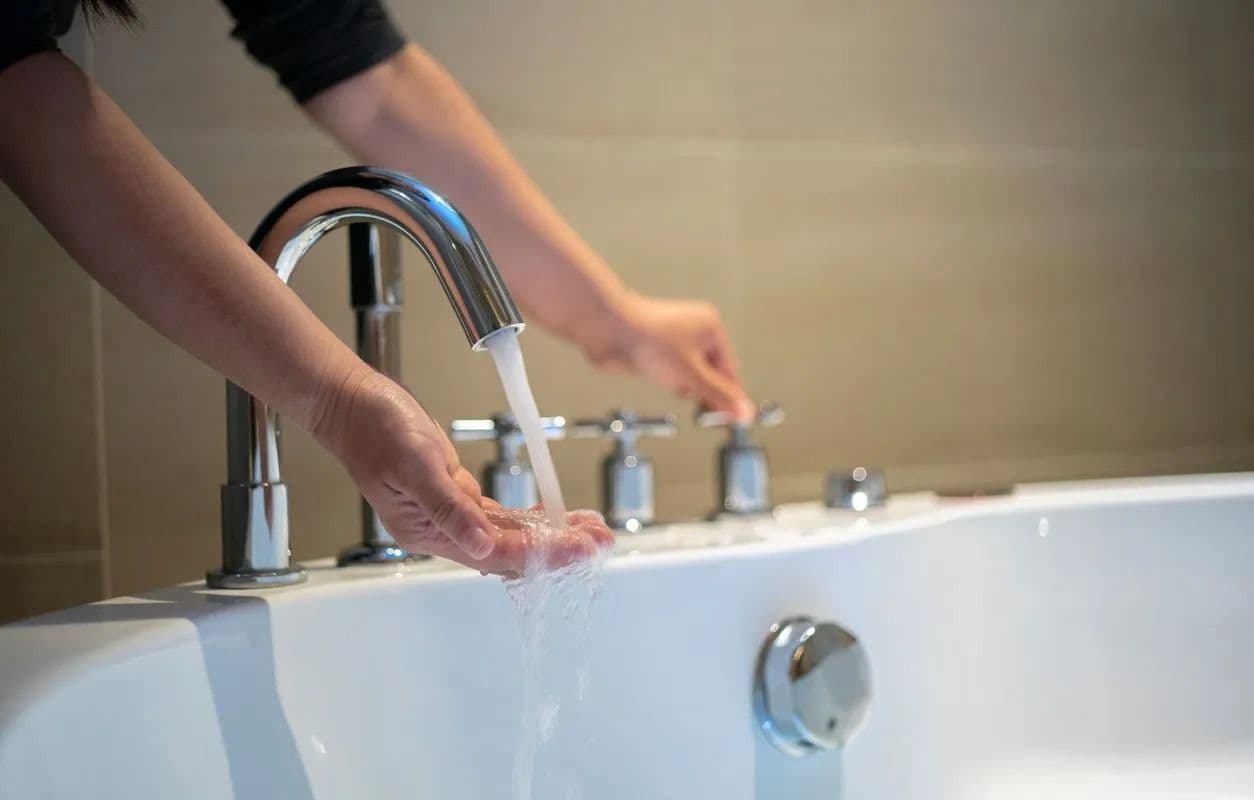 washing hands with bathtub faucet water