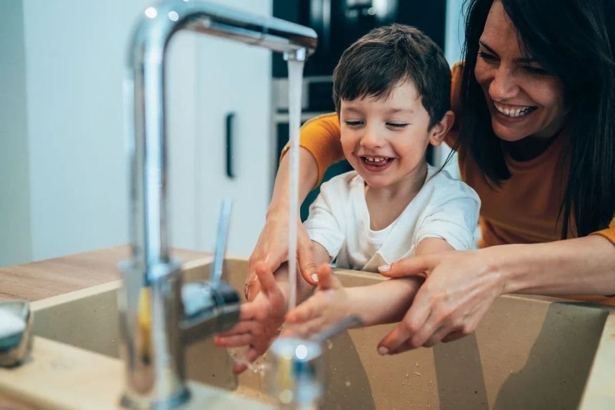 mom helping kid wash his hands