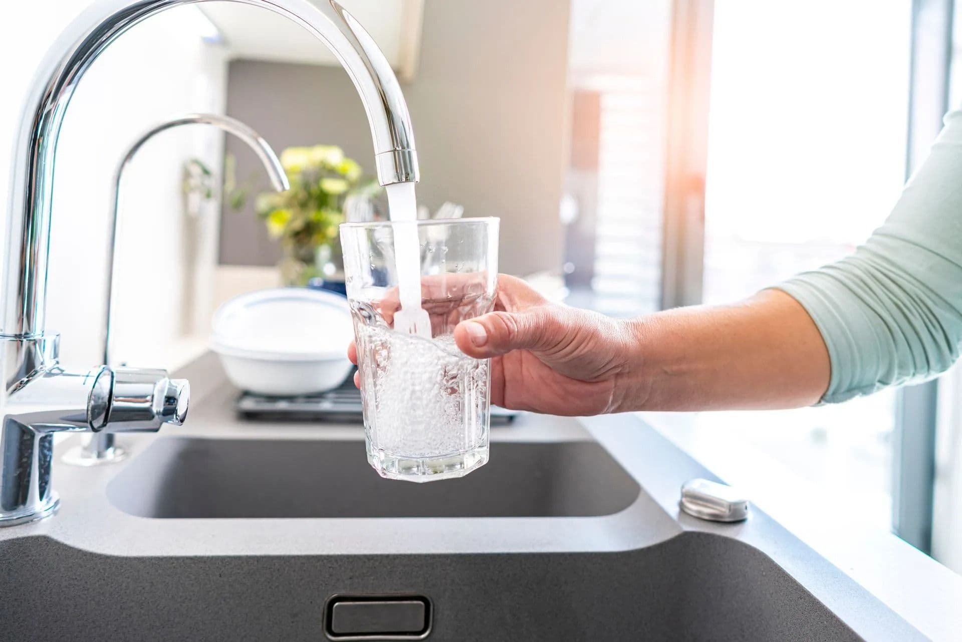 filling up glass with faucet water