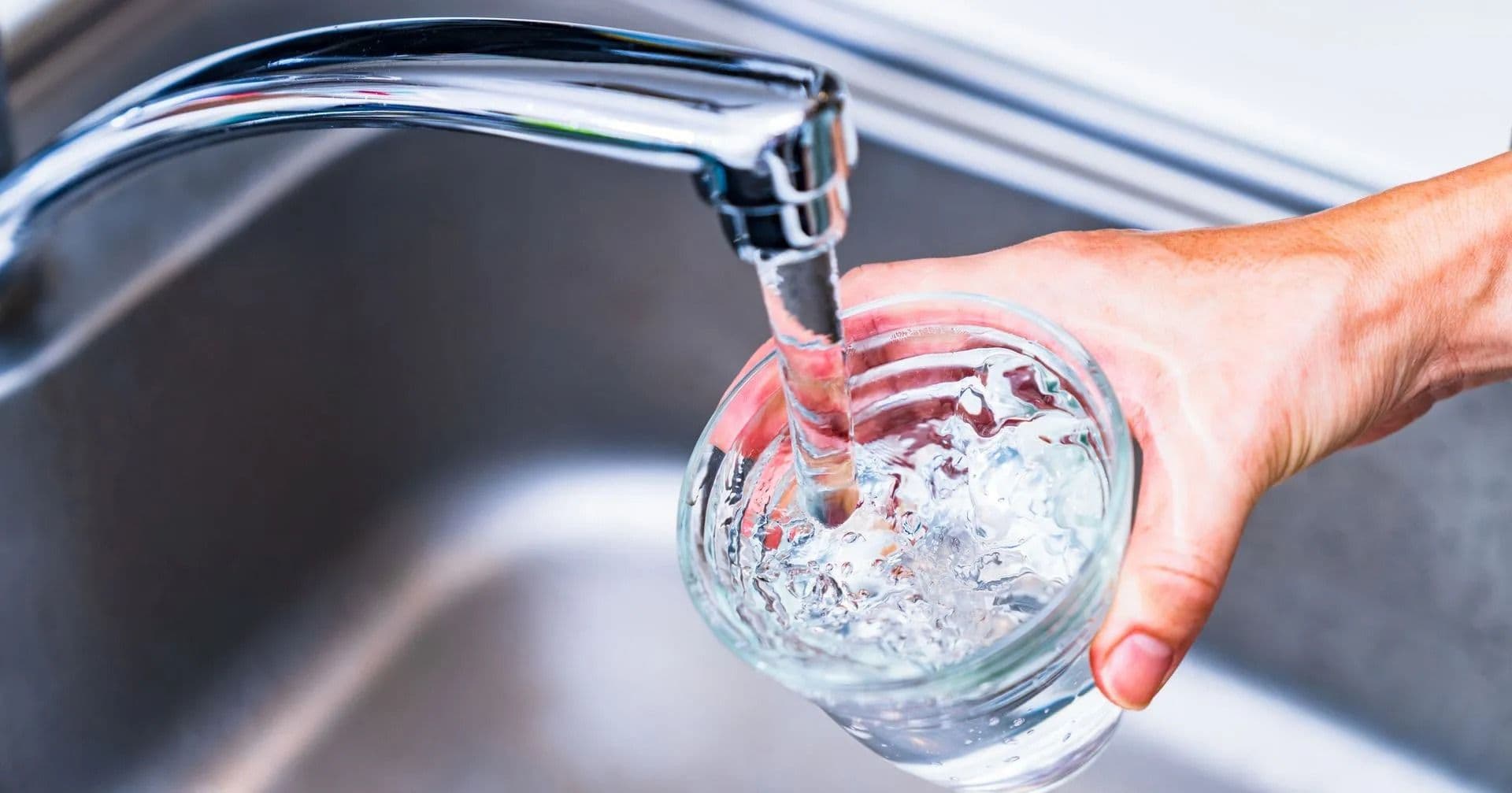 filling up glass with faucet water