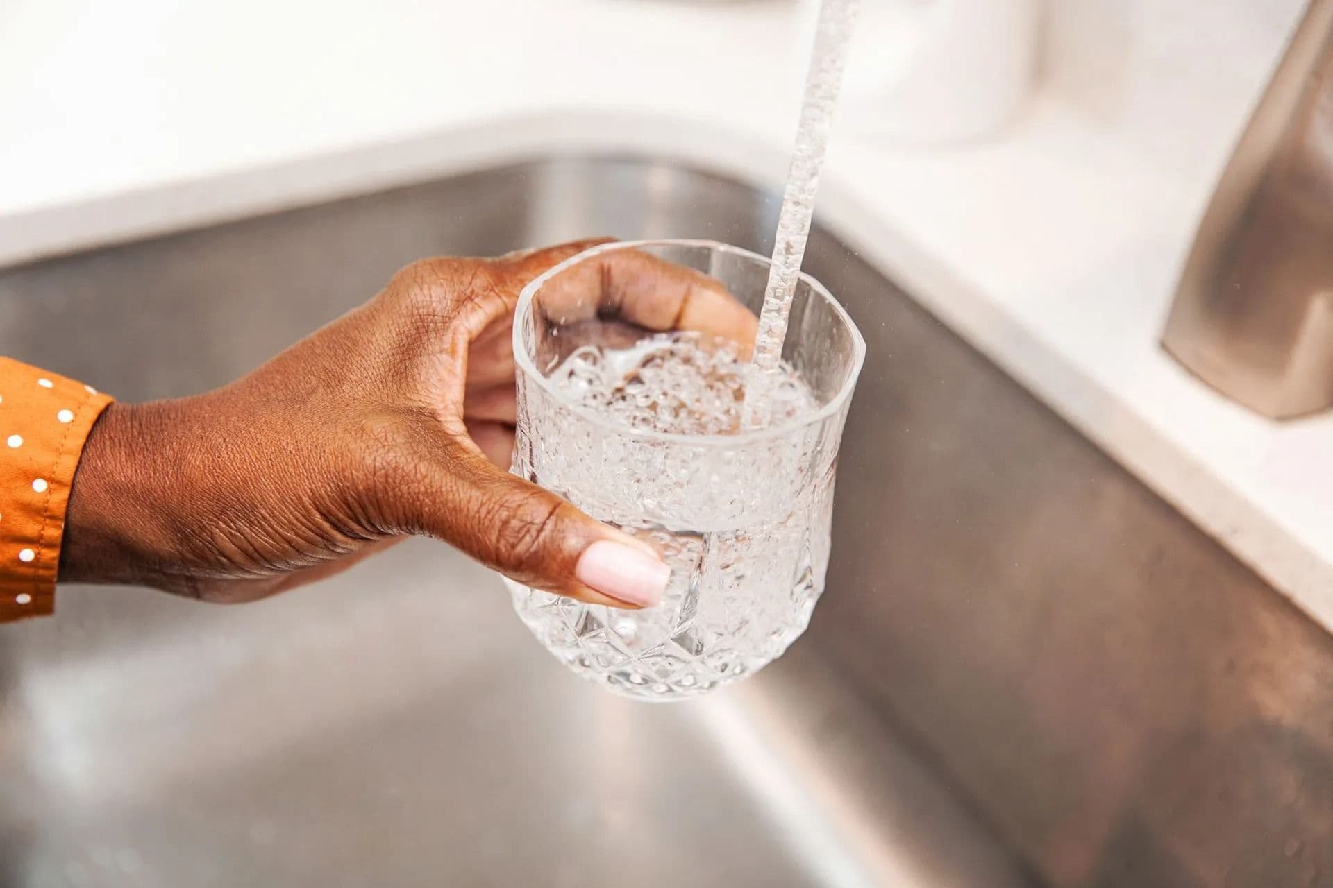 filling up glass with faucet water