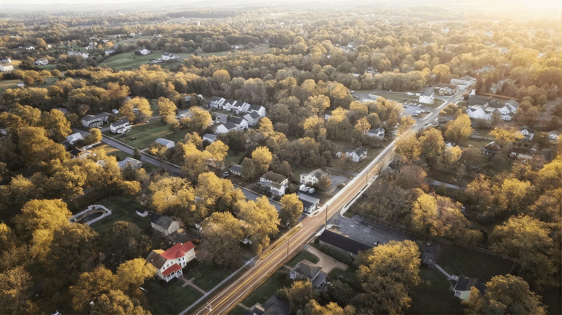 Aerial view of a tree-lined residential Virginia community at sunrise, highlighting neighborhoods and homes served by trusted local plumbing, water treatment, and home service professionals.